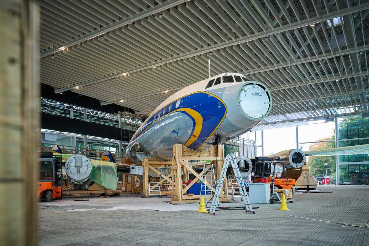 Teilweise montiertes historisches Flugzeug Super Star steht auf einem Gerüst, Nase und Triebwerke fehlen